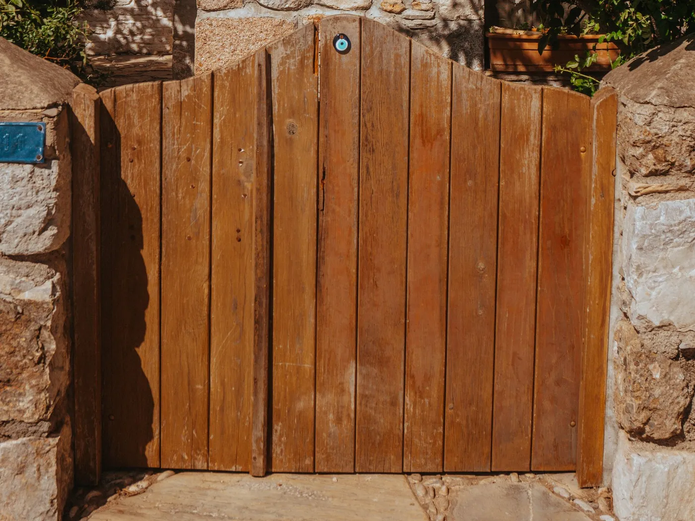 An arched cedar gate set into a stone wall